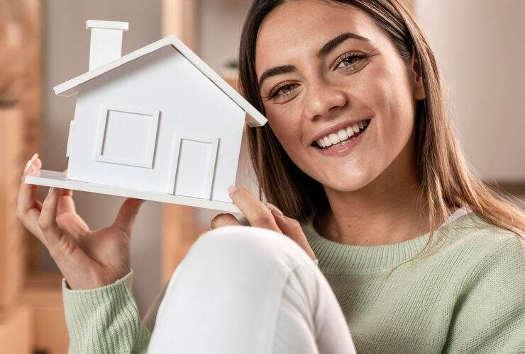 Donna sorridente con modellino di casa