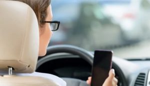 Illustrazione di una guidatrice con il telefono in mano (Depositphotos)