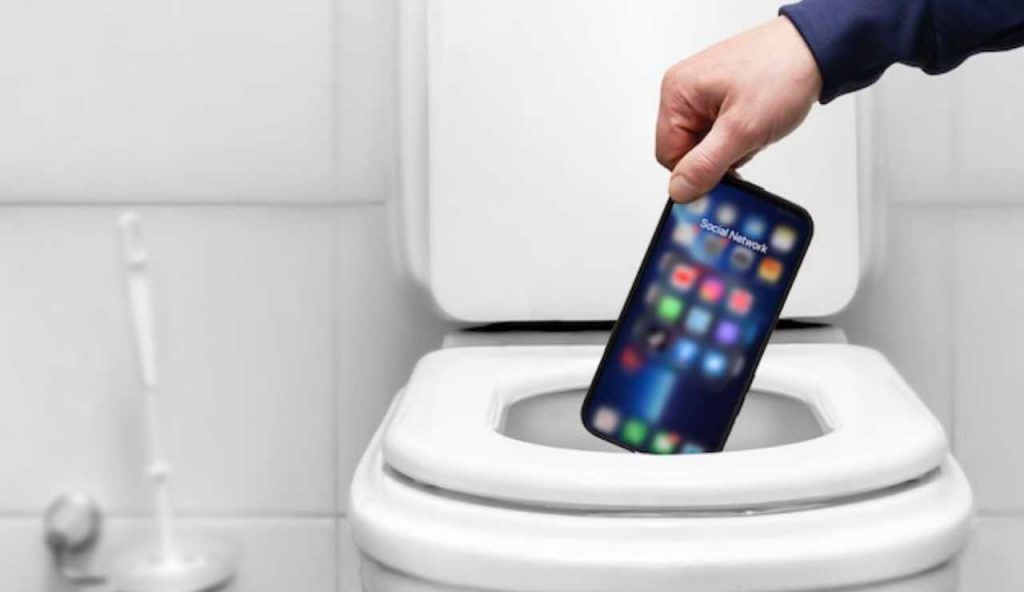 Persona che butta il telefono nel water