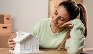 Donna sorridente con modellino di casa