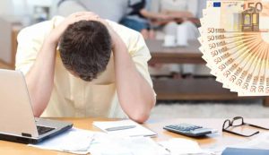 Uomo disperato e soldi (Depositphotos foto) - www.notiziesecche.it